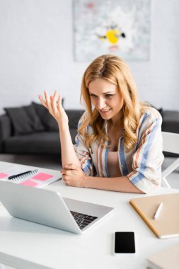 Evde not defterlerinin yanında konuşan kadınların seçici odak noktası. 