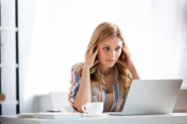 Laptopa bakan düşünceli kadının seçici odağı 
