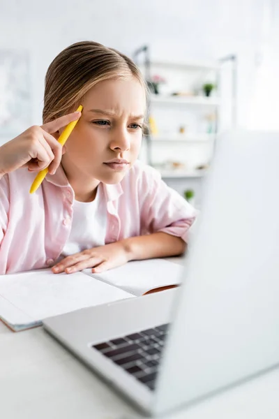 Enfoque Selectivo Del Niño Enfocado Sosteniendo Pluma Mirando Portátil — Foto de Stock