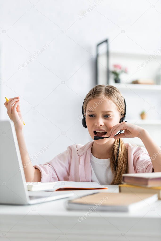 Selective focus of kid using headset during electronic learning at home 
