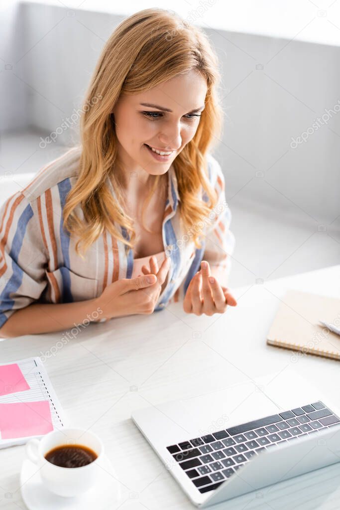 Selective focus of woman talking during webinar at home 