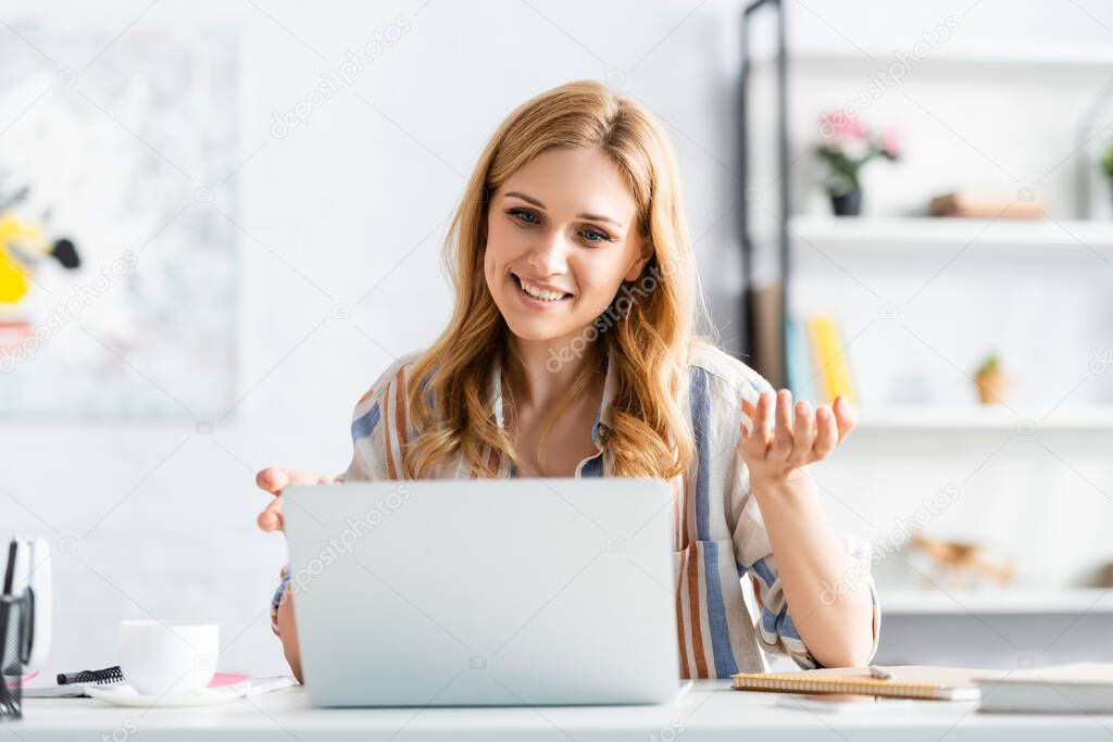  Selective focus of woman smiling and talking during webinar 