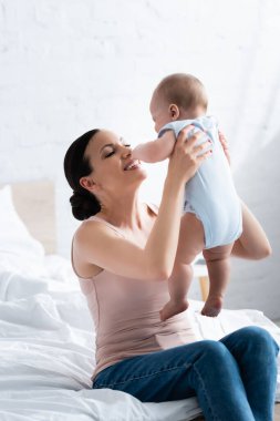 Kollarında neşeli bir anne. Çıplak ayaklı tatlı bir çocuk. 