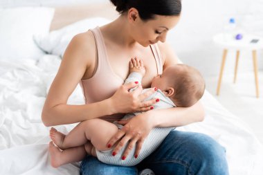 İlgili anne, bebeğini yatak odasında emziriyor. 