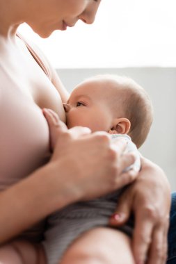 Seçici anne seçici odak yatak odasında erkek bebek emziren 