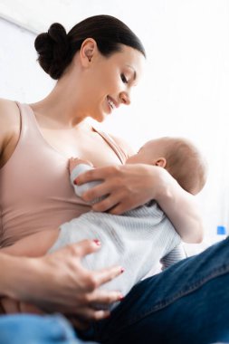 low angle view of happy mother breastfeeding baby boy  clipart