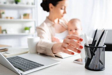 Annesinin kollarını tutarken kırtasiyeye uzanması güzel bir bebek evlat. 