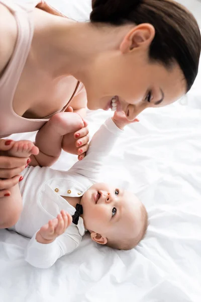 Alegre Madre Tocando Descalzo Pies Lindo Bebé Hijo Bebé Mameluco —  Fotos de Stock