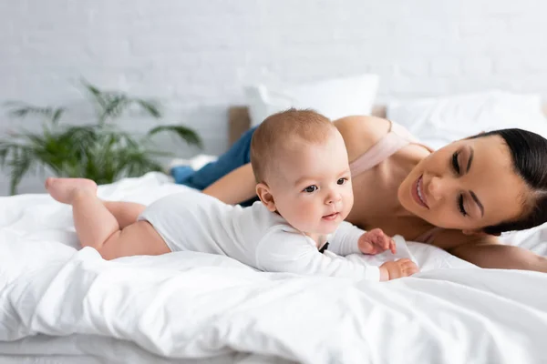 Happy Mother Looking Barefoot Infant Son Bed — Stock Photo, Image