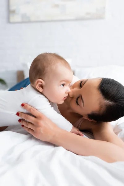 Woman Kissing Cute Infant Son Baby Romper Lying Bed — Stock Photo, Image