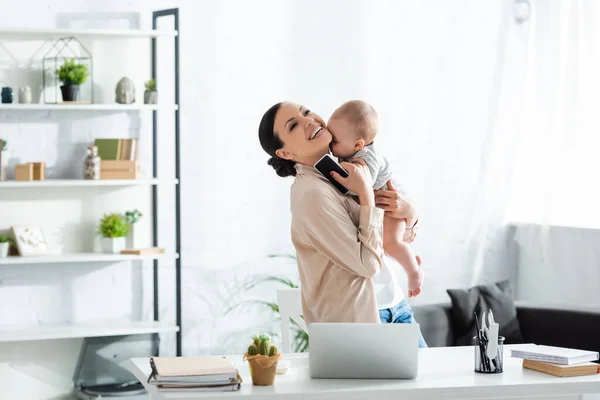 Lycklig Mor Hålla Armar Spädbarn Son Och Hålla Smartphone Med — Stockfoto