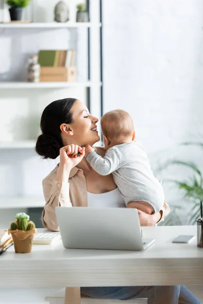 Cheerful Mother Holding Arms Infant Son Laptop Table — Stock Photo, Image