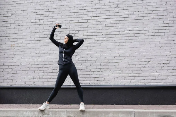 Femme Musulmane Tenant Smartphone Avec Écran Blanc Près Mur Briques — Photo