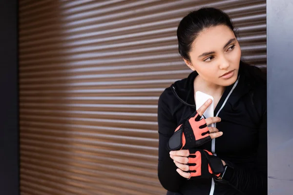 Joven Deportista Sosteniendo Teléfono Inteligente Mirando Hacia Otro Lado — Foto de Stock