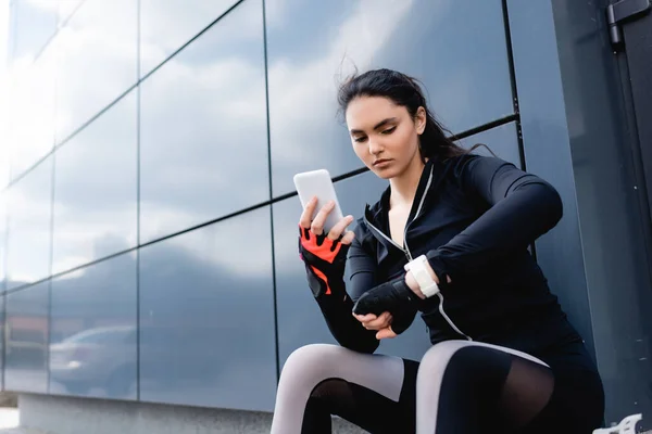 Junge Sportlerin Hält Smartphone Der Hand Und Schaut Auf Fitness — Stockfoto