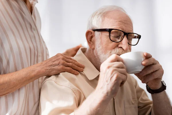 Выборочный Фокус Пожилой Женщины Обнимающей Мужа Пьющей Кофе Дома — стоковое фото