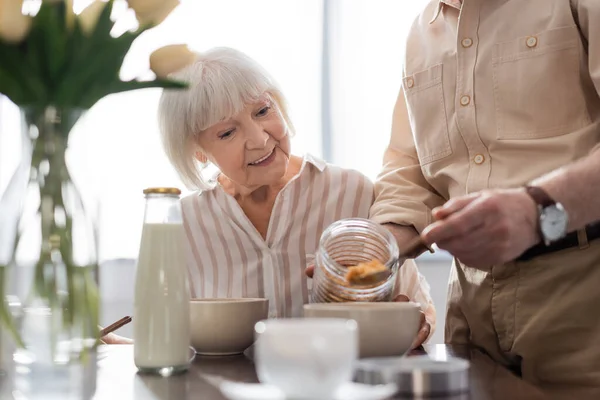 Selective Focus Smiling Senior Woman Sitting Man Pouring Cereals Bowl — Stock Photo, Image