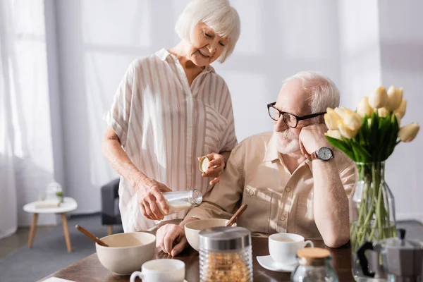 Focus Selettivo Della Donna Anziana Sorridente Versando Latte Ciotola Vicino — Foto Stock