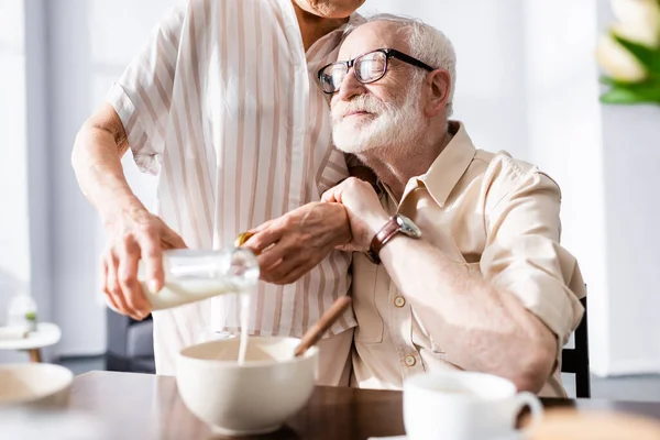 Selective Focus Senior Man Embracing Wife Pouring Milk Bowl Breakfast — Stock Photo, Image