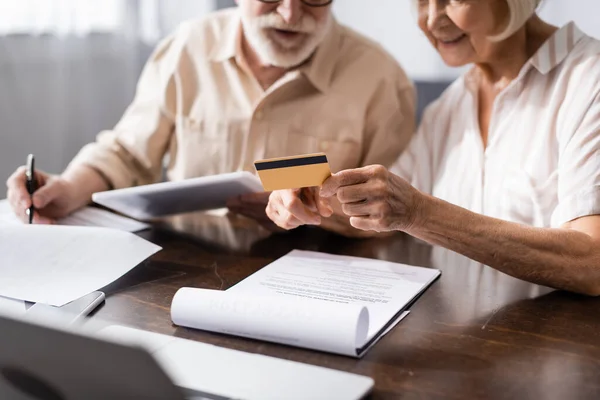 Selective Focus Senior Woman Holding Credit Card While Husband Writing — Stock Photo, Image