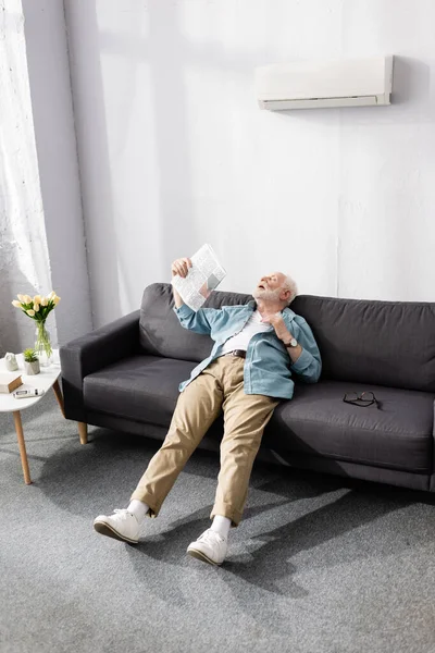Senior Man Waving Newspaper While Suffering Heat Home — Stock Photo, Image