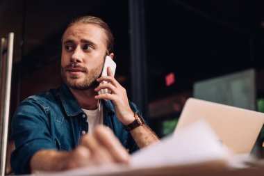 seçici odaklı iş adamı gözünü kaçırıyor ve akıllı telefondan konuşuyor. 