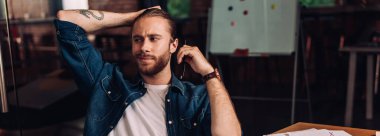 panoramik yönelimli iş adamı kalem tutuyor ve başka yere bakıyor