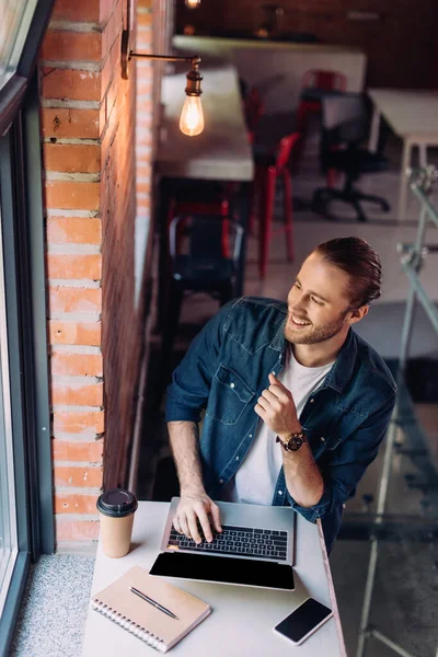 Wysoki Kąt Widzenia Szczęśliwy Biznesmen Patrząc Okno Pobliżu Laptopa Smartfona — Zdjęcie stockowe