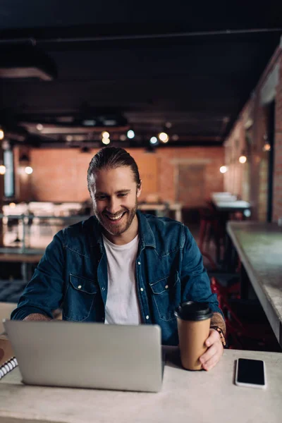 Mutlu Adamı Laptopa Bakıyor Boş Ekranlı Akıllı Telefonun Yanındaki Kağıt — Stok fotoğraf