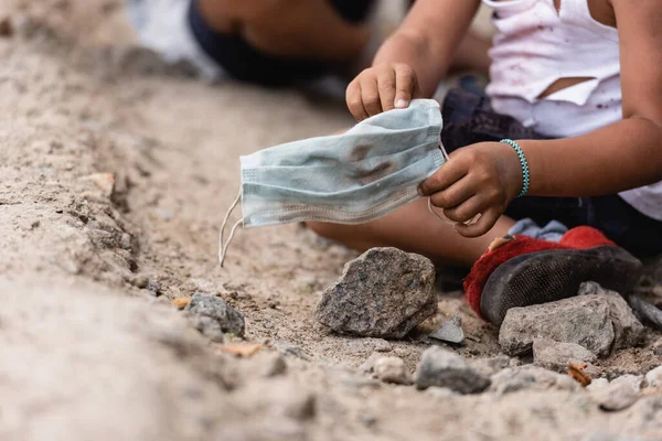 Recortado Vista Pobre Africano Americano Niño Sosteniendo Sucio Médico Máscara — Foto de Stock