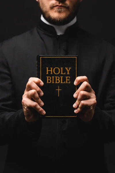 牧师拿着一本圣经的剪影 上面有神圣的圣经字体 用黑色隔开 — 图库照片