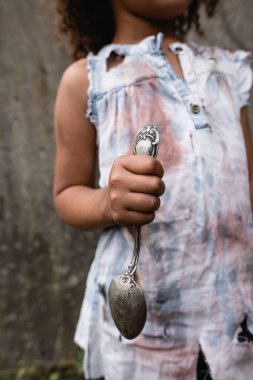 Kentsel caddede kirli kaşık tutan zavallı Afro-Amerikan çocuk manzarası 