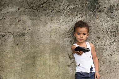 Fakir Afrikalı Amerikalı çocuğun seçici odak noktası şehir sokağındaki beton duvarın yanında cüzdanını göstermesi. 
