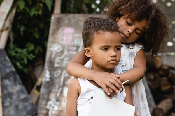 Poor African American Child Holding Pencil Hugging Sad Brother Torn — Stock Photo, Image