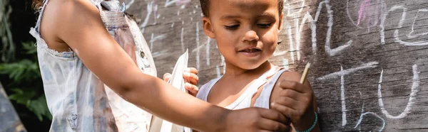 Cultivo Panorámico Niños Afroamericanos Pobres Ropa Rasgada Pie Cerca Pizarra —  Fotos de Stock