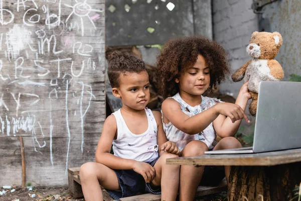 Selektivní Zaměření Chudé Africké Americké Dítě Ukazuje Prstem Notebook Venku — Stock fotografie