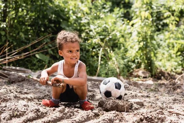 Sonriente Niño Afroamericano Con Cara Desordenada Sosteniendo Ramita Madera Cerca — Foto de Stock