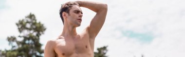 Tişörtsüz adamın saça dokunuşunun panoramik görüntüsü. 