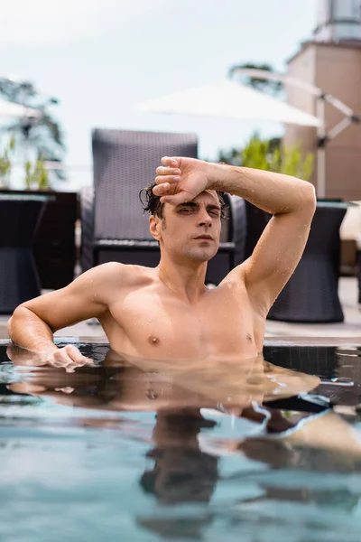 Selective Focus Muscular Man Looking Camera While Sitting Swimming Pool — Stock Photo, Image