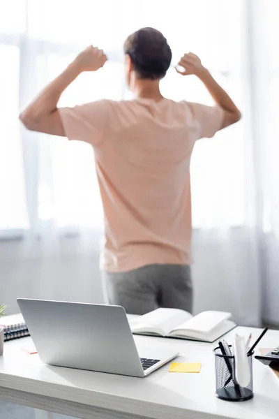 Visão Traseira Homem Que Estende Perto Laptop Casa — Fotografia de Stock