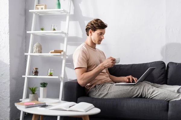 Selective Focus Handsome Freelancer Holding Cup Coffee Using Laptop Notebooks — Stock Photo, Image