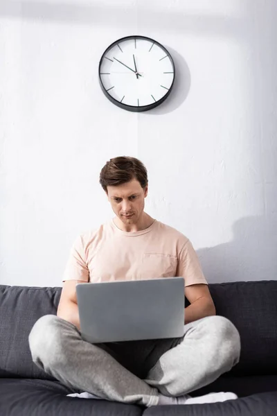 Selective Focus Focused Teleworker Using Laptop While Sitting Crossed Legs — Stock Photo, Image