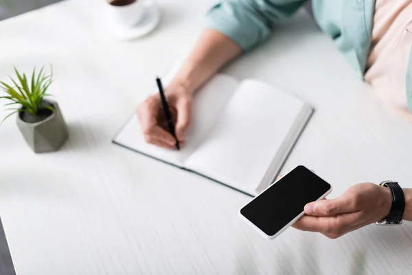 Vista Cortada Homem Segurando Smartphone Com Tela Branco Enquanto Escreve — Fotografia de Stock