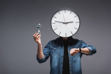 Man with clock on head, wristwatch and hourglass on grey background, concept of time management  clipart