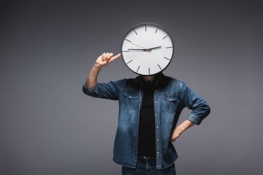 Man with clock on head pointing with finger on grey background, concept of time management  clipart