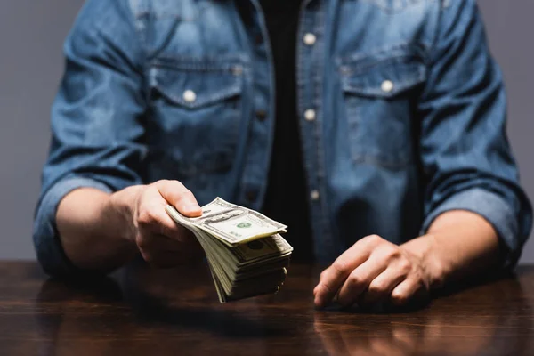 Gri Masada Dolarları Gösteren Bir Adam Görüntüsü — Stok fotoğraf