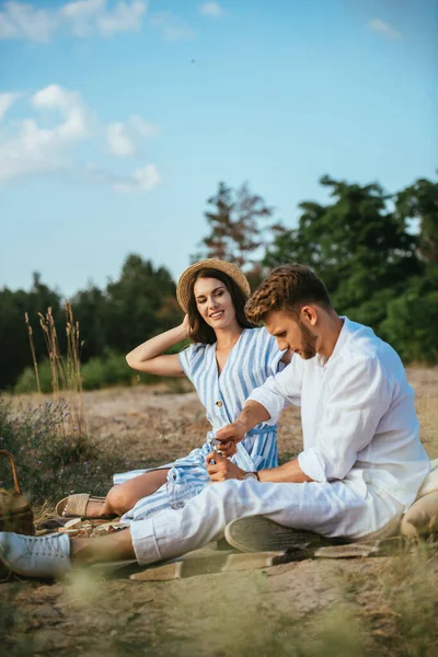 Focalizzazione Selettiva Donna Felice Cappello Paglia Guardando Fidanzato Bottiglia Apertura — Foto Stock