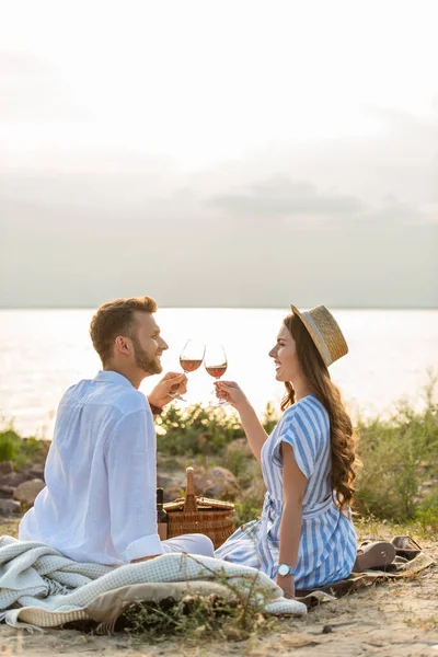 坐在湖边时 幸福的情侣们边看边喝红酒边碰杯 — 图库照片