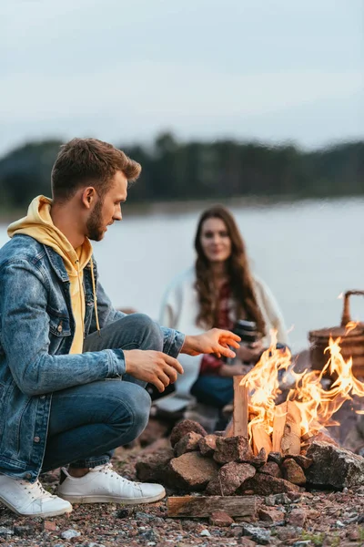 Enfoque Selectivo Del Hombre Guapo Sentado Mirando Hoguera Ardiente Cerca — Foto de Stock