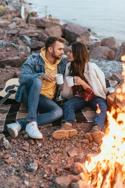 Couple Looking Each Other While Holding Cups Sitting Blanket Bonfire — Stock Photo, Image